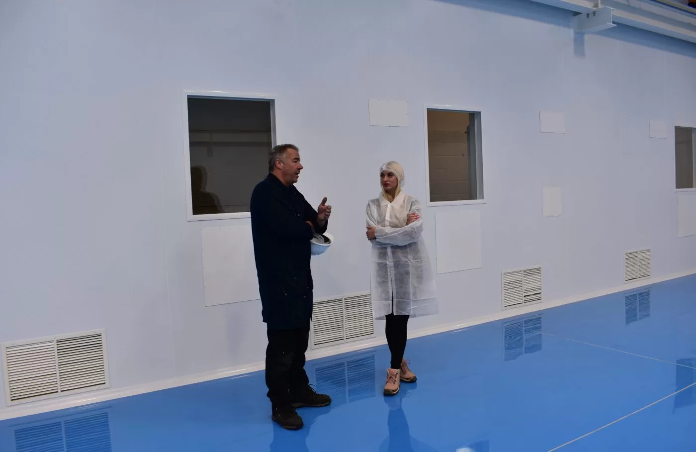 Two people in large room with blue flooring
