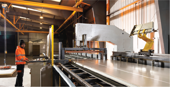 Isoclad production operative using a machine to cut an insulated panel on the CustomClad line.