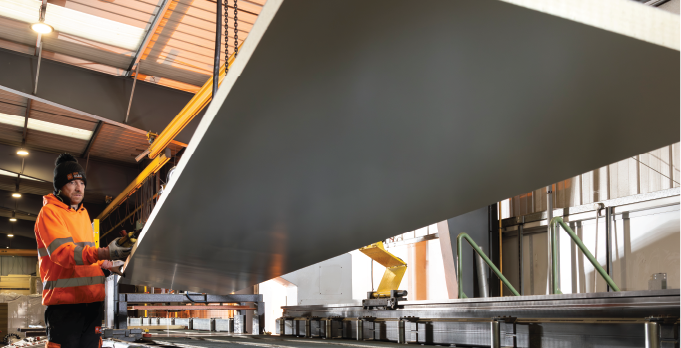 Isoclad production operative positioning a insulated panel on to the CustomClad line.