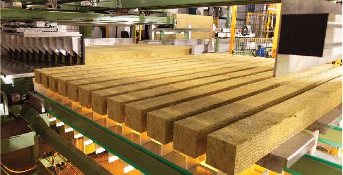 Mineral wool lamellas arranged on the production line ready for panel manufacture.