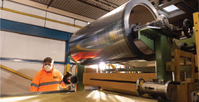Isoclad production operative monitoring steel coil feeding into the manufacturing line.