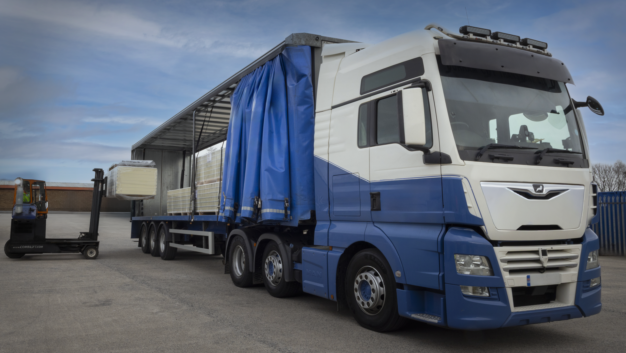 Isoclad insulated panels being loaded onto a delivery lorry using a forklift.